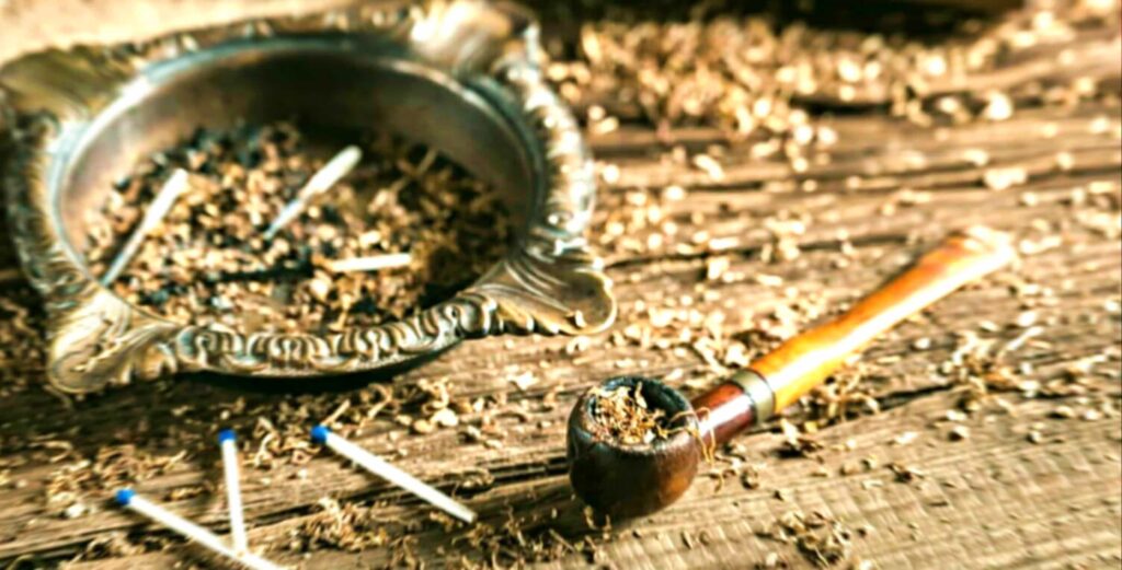 Побалуйте свои чувства тщательно изготовленной трубкой с банкой табака Simply Latakia, красиво выставленной на деревенском деревянном столе.